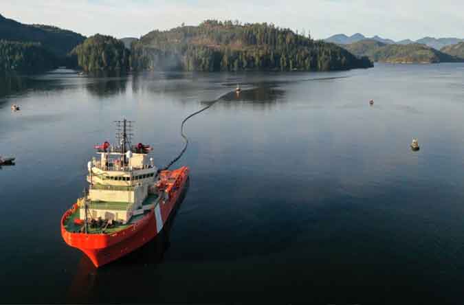 Marine spill responders deploy sorbent booms to collect oil leaking from the sunken vessel off Vancouver Island. (Bligh Island Shipwreck Unified Command)
